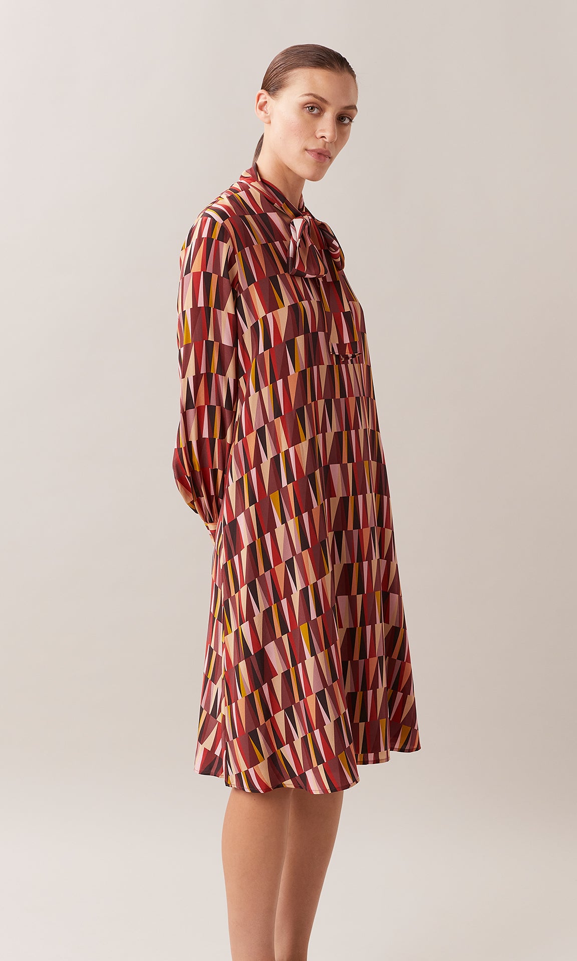 Pyramid pure Italian silk crepe de chine V-neck long cuff sleeve trapeze midi dress with neck tie in rhubarb red, berry, and peach orange geometric print design