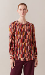 Pyramid Italian pure silk crepe de chine crew neck gathered long wide cuff sleeve blouse with neck keyhole opening in rhubarb red, berry, and peach orange geometric print design